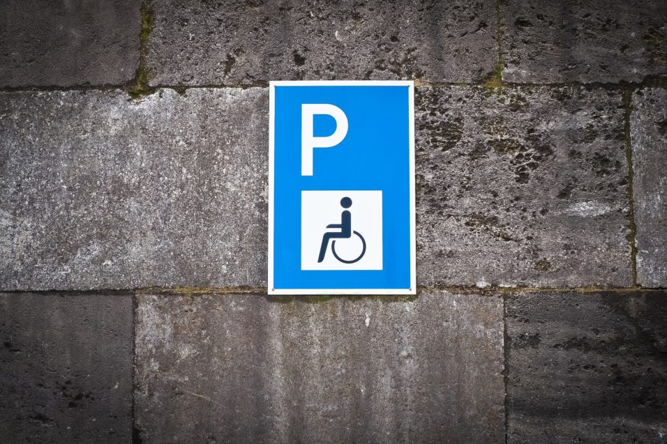 Ein Rollstuhlparkplatzschild an einer Mauer