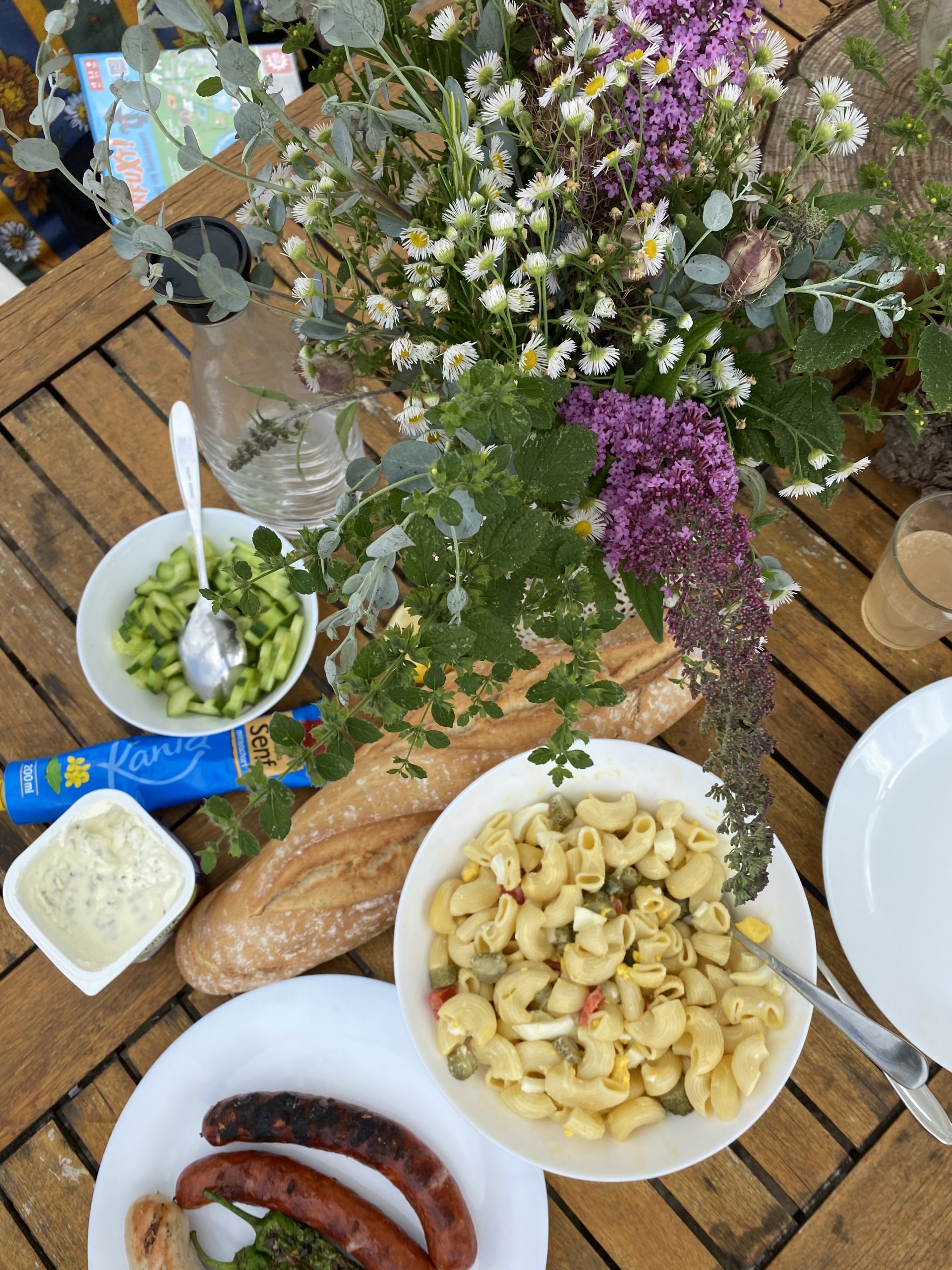 Ein gedecketer Tisch mit Salaten, Brot und Quark 