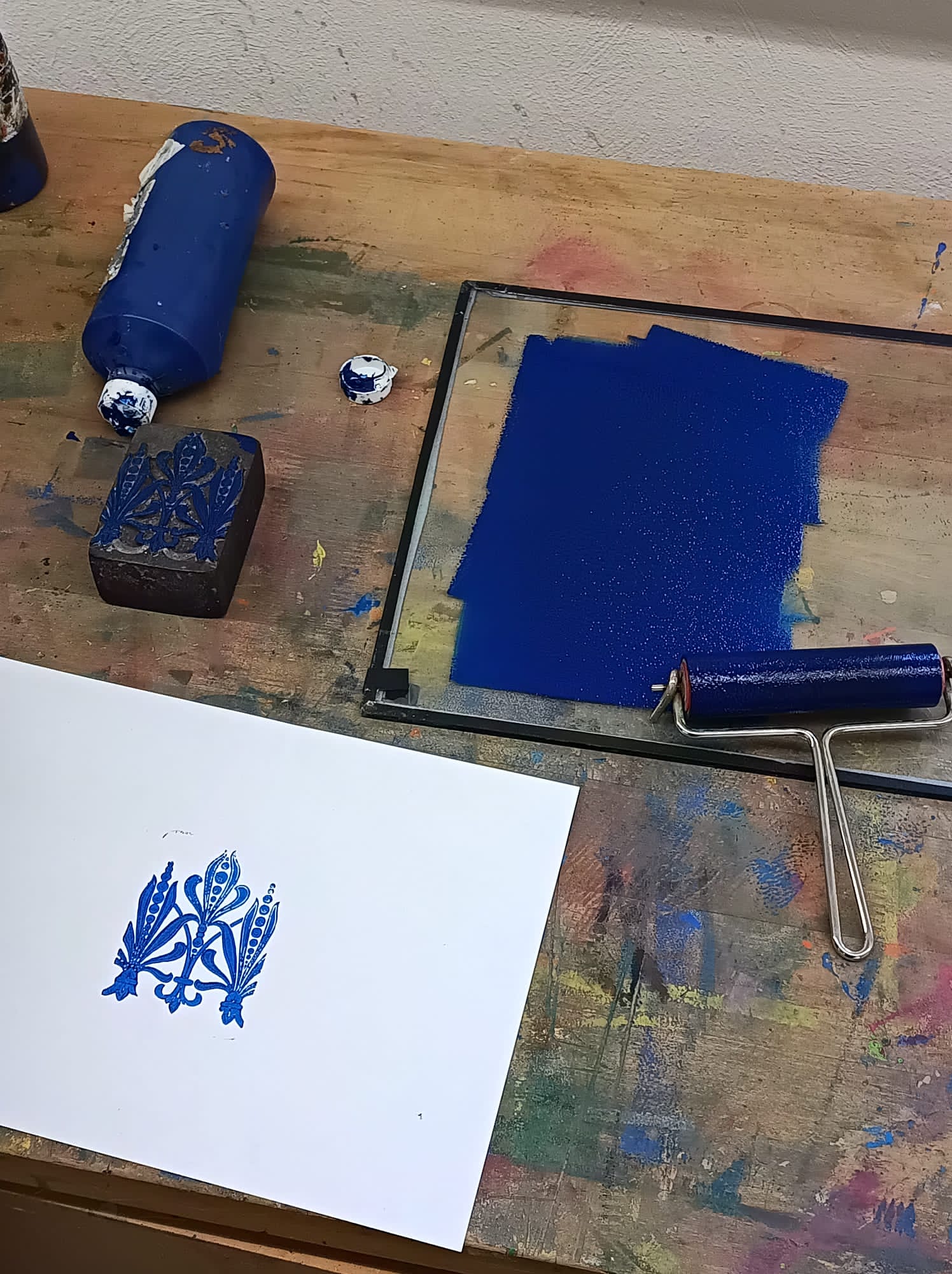 Druckrolle und blaue Farbe mit einem Ornament 