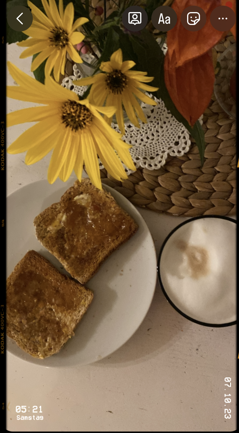 Glebe Blumen, 2 Toastbrote auf dem Frühstückstisch und Kaffee. Dazu die Zeit 5:22
