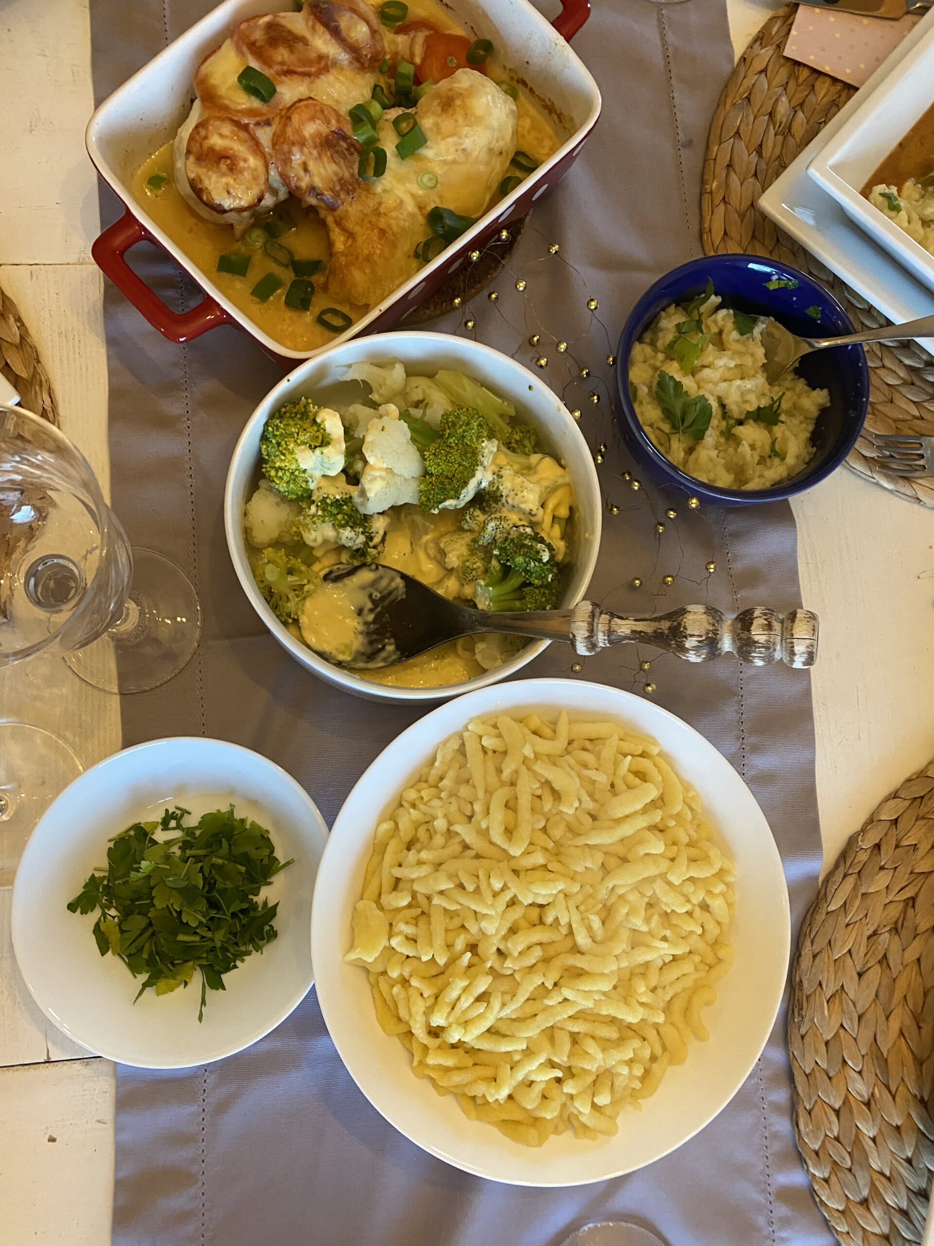 Ein gedeckter Tisch mit Spätzle, Sauce, überbackener Putenbrust und Gemüse 