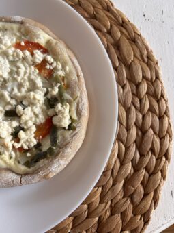 Brotfladen auf dem Teller mit Tomaten und Schafskäse